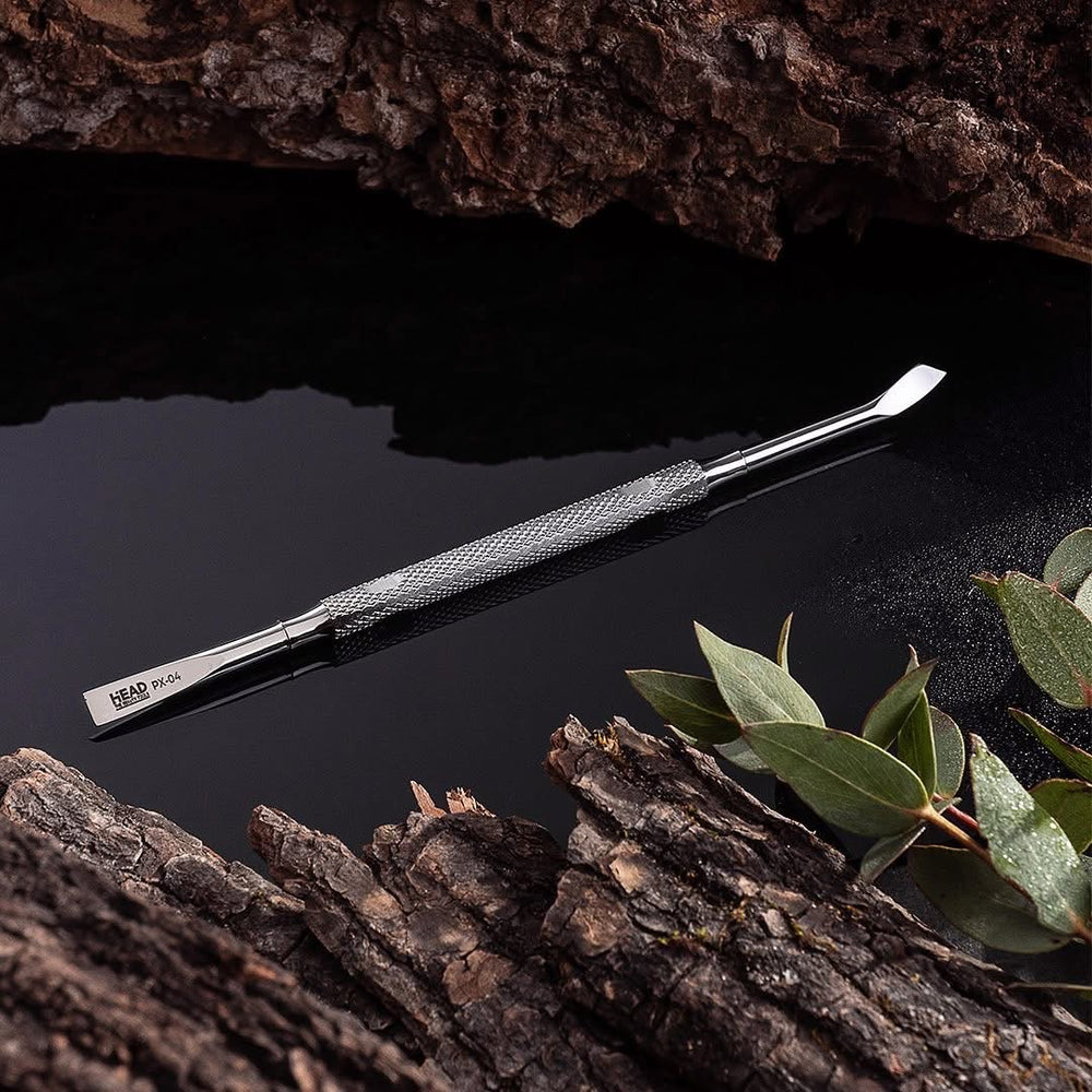Metal tool on a dark surface with leaves and wood