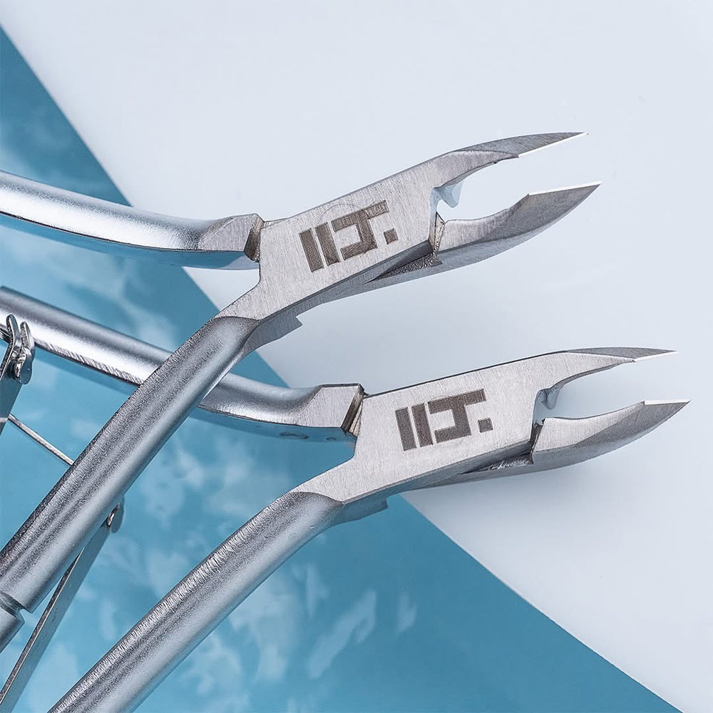 Pair of silver cuticle nippers with a Head Tools logo on a blue and white background